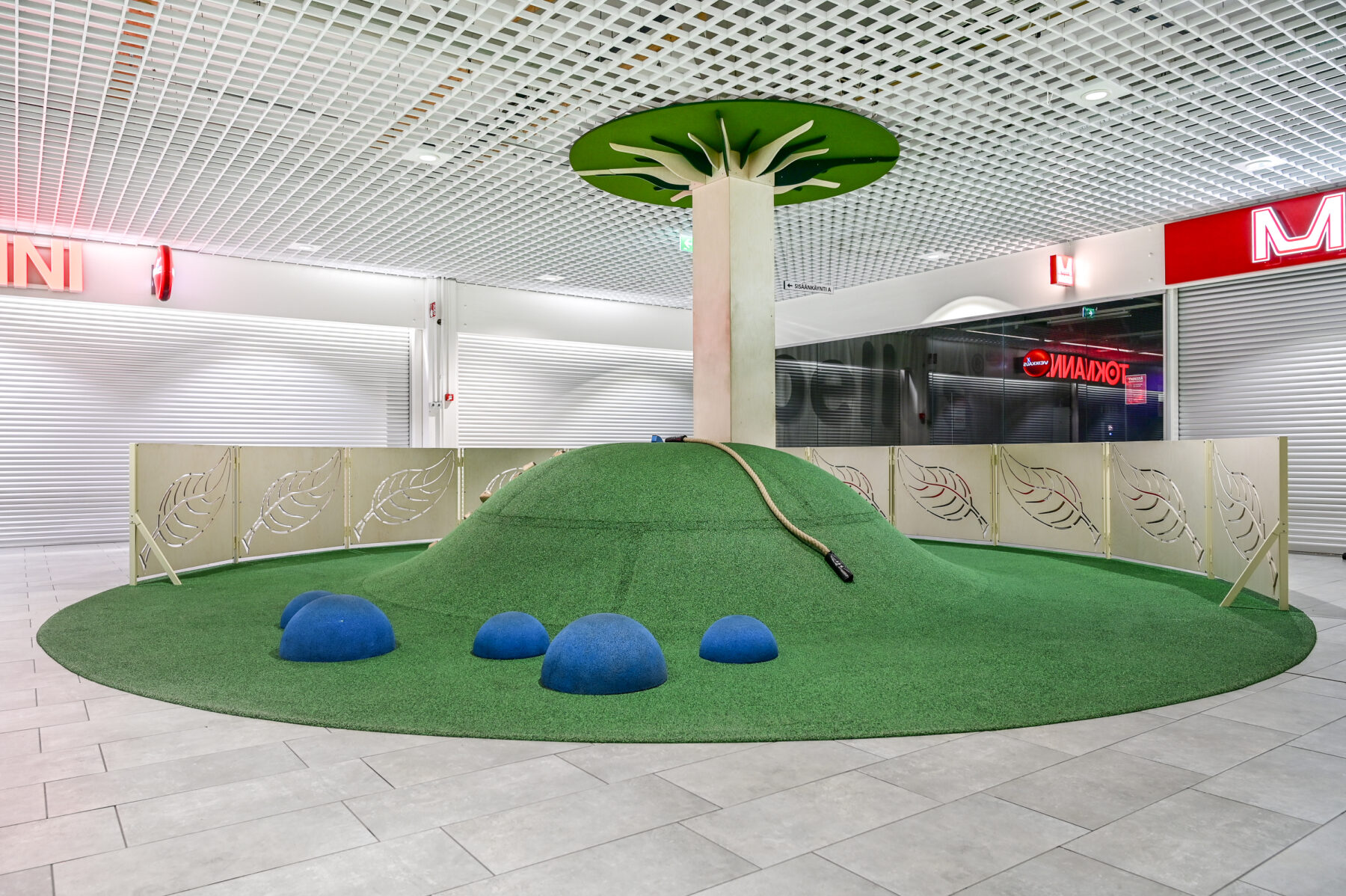 Ideapark Oulu A-aula leikkipaikka, kiipeilykumpu, kiipeilyköysi ja siniset lattian puolipallot. Leikkipaikan sisustussuunnittelu Sisu interior.